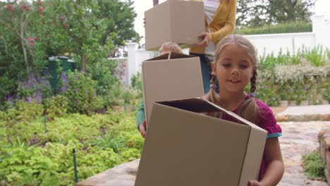 Mother-and-children-carrying-cardboard-boxes-towards-home-4k