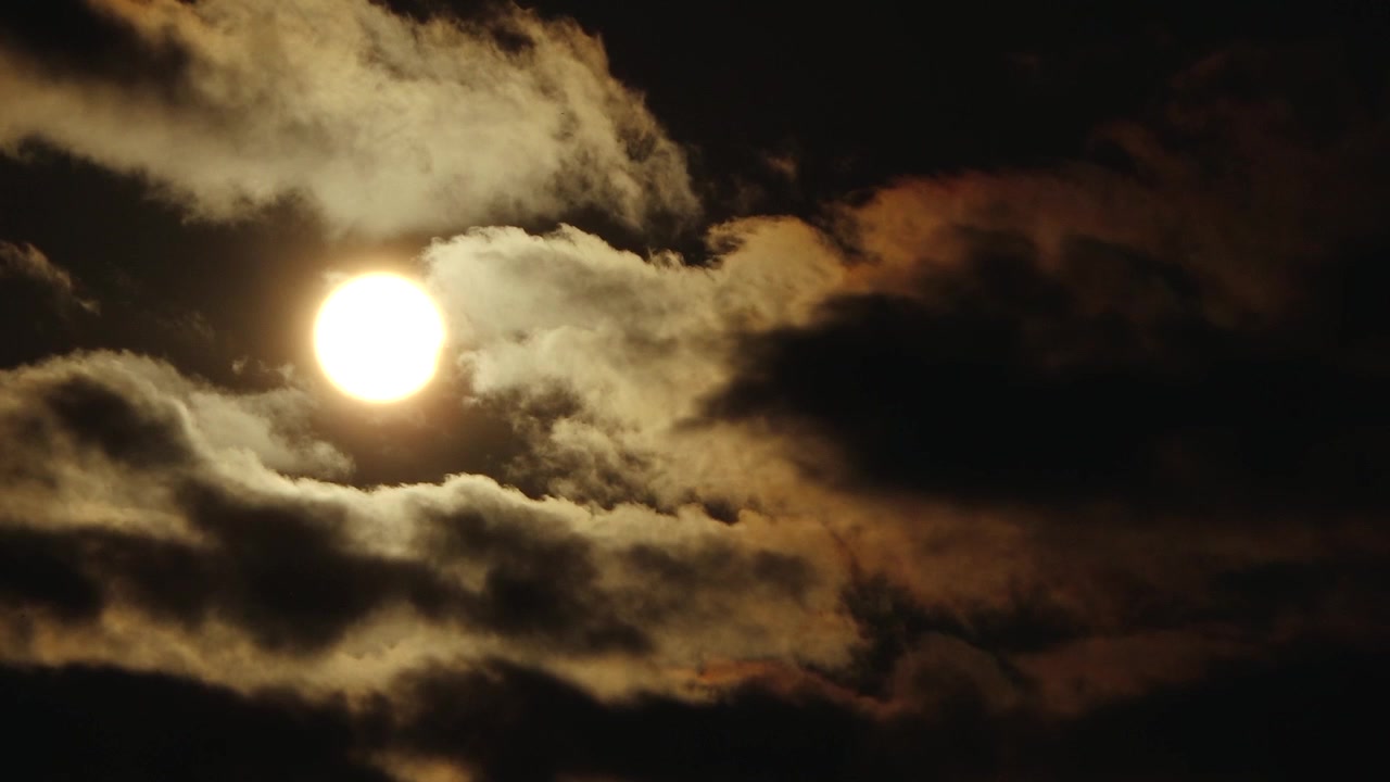Eclipse Solar Parcial Brilha em um Céu Escuro Enquanto a Lua Obscurece Parte do Sol, Com Nuvens Dramáticas Formando uma Camada Silhuetada Abaixo