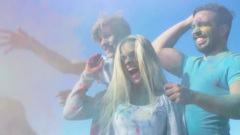 multi-ethnic group of young people throw colorful powder at each other in celebration of holi festival. they have enormous fun on this sunny day.