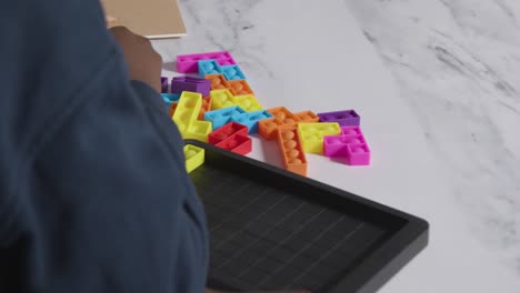 close up of boy on asd spectrum solving shape puzzle on white background 3