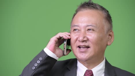 성숙한 일본 사업가 전화를 사용