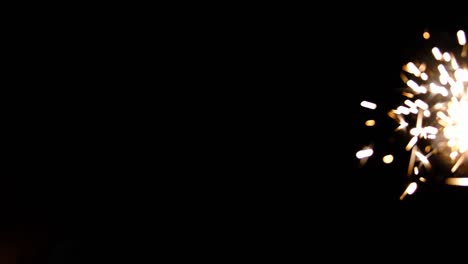 fuego bengal. vela de chispas de año nuevo en un fondo negro. concepto de fiesta de vacaciones