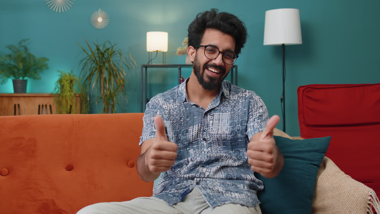 Happy indian man looking approvingly at camera showing thumbs up like positive sign good news