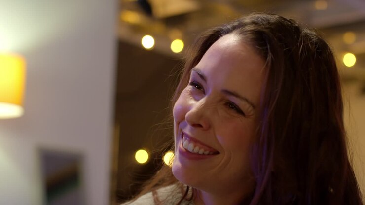 Close Up Of Woman Sitting On Sofa At Home Or In Bar Or Cafe Talking With Friends 1