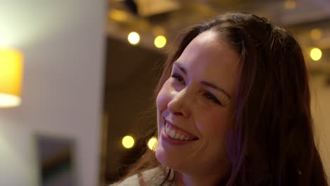 close up of woman sitting on sofa at home or in bar or cafe talking with friends 1