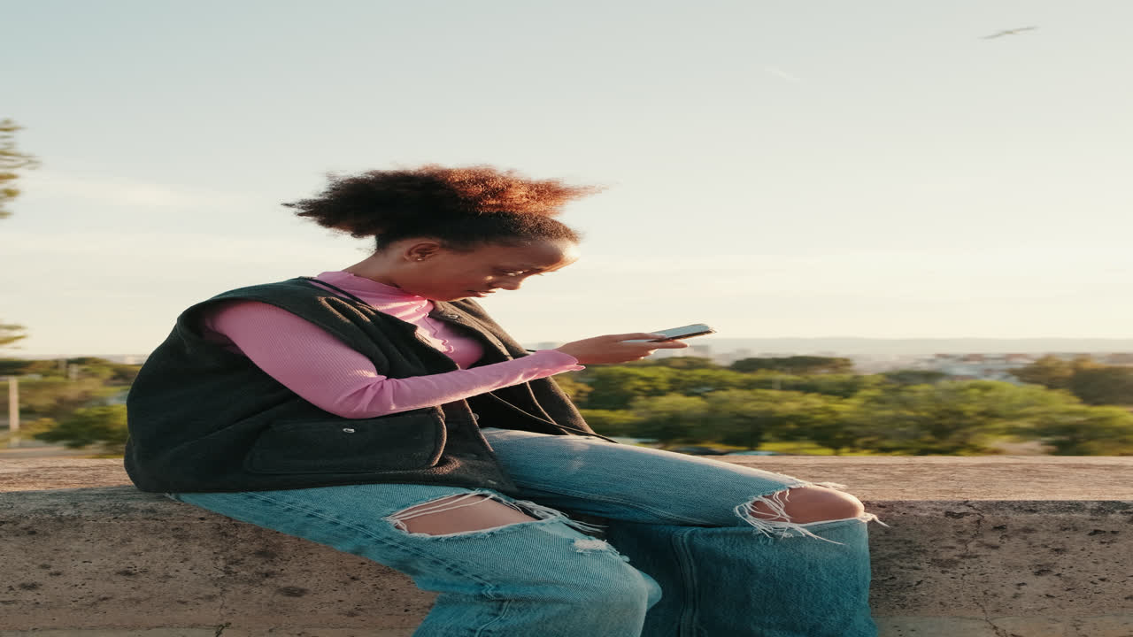 Donna che usa il telefono al parco al tramonto