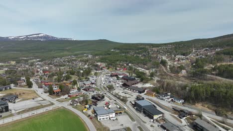 Dombaas-and-roads-leading-to-Trondheim-and-Romsdal---Reverse-ascending-aerial-above-countryside-highland-town