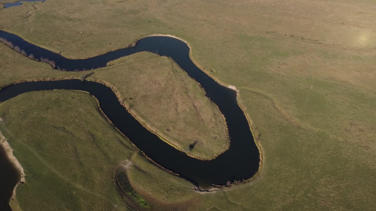 aerial view of a beautiful winding river flows among the fields, which flows picturesquely, creating incredible landscapes. between flooded fields and swamps.