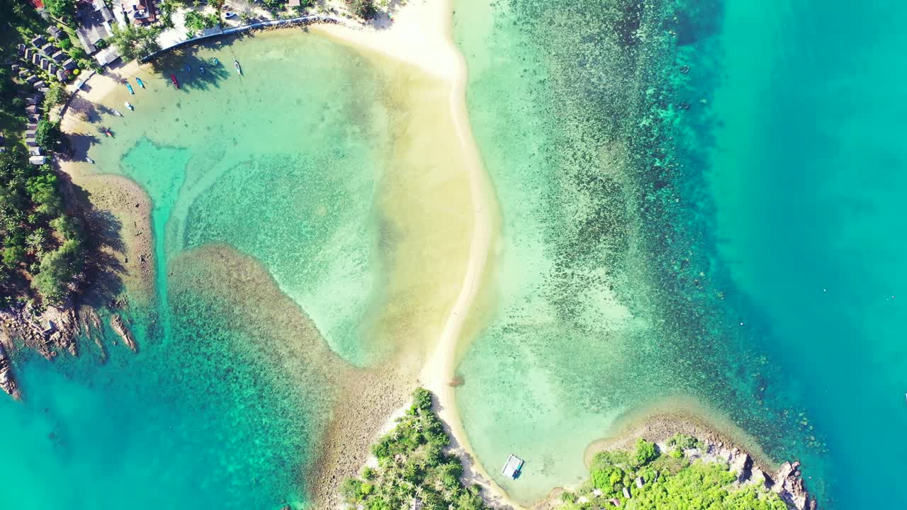 Paradise bay with coral reefs under calm clear water of turquoise lagoon washing white sandy beach near vacations resort in Thailand