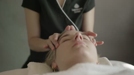 young woman getting professional temple massage in natural lighting