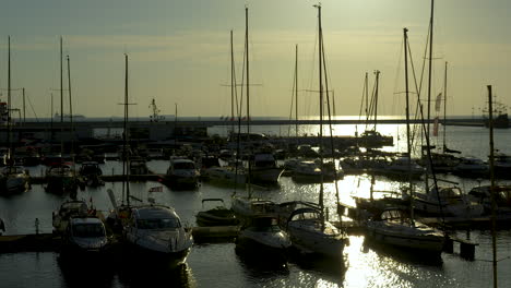 sunset over marina with silhouetted boats and yachts anchored