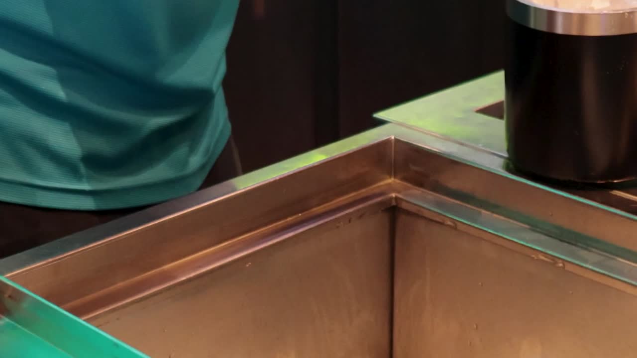 바텐더는 드라이빙 레인지 바에서 얼음 버을 채니다.