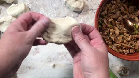 hacer bollos al vapor preparando y estirando la masa y rellenando con carne