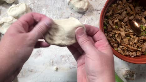 making steamed buns by preparing and stretching dough and stuffing with meat