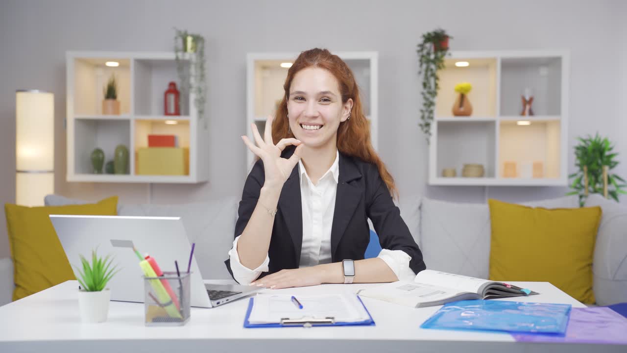 mujer trabajadora de oficina en casa haciendo un gesto positivo a la cámara.