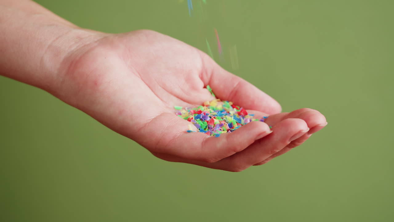 Colorful Confetti Falling into Hand