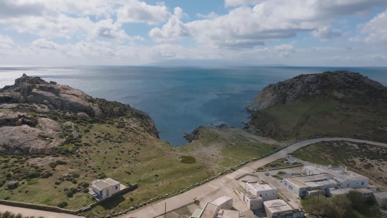 A cinematic drone reveal of the traditional fishing village of Divounia in Mykonos, with its beach and authentic island charm by the Aegean Sea