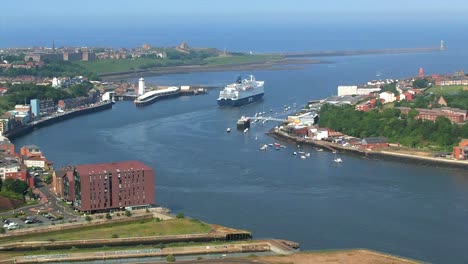 imágenes de drones de un ferry navegando en el río tyne, con la ciudad costera de tynemouth y el puerto en el fondo