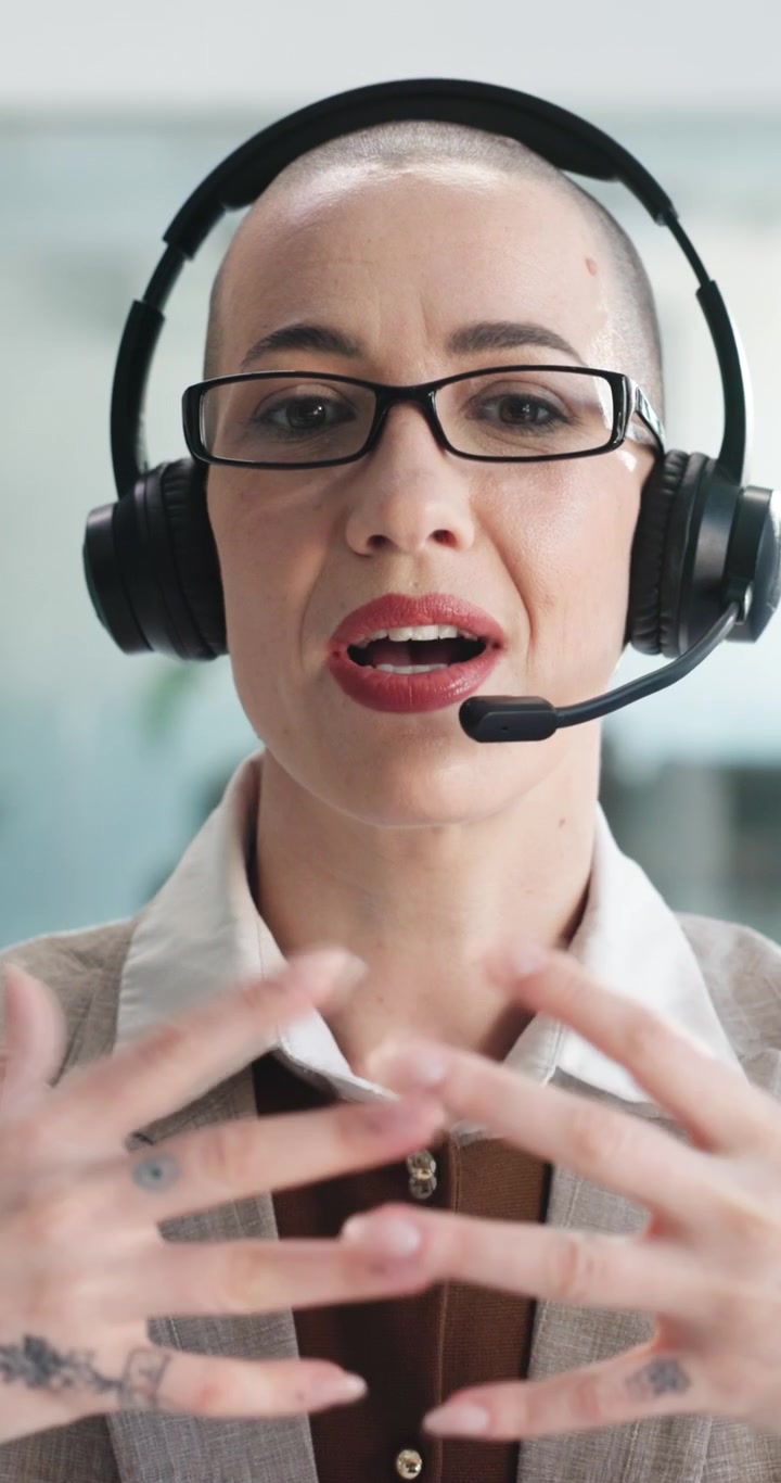Donna professionista con cuffie che parla durante una videochiamata