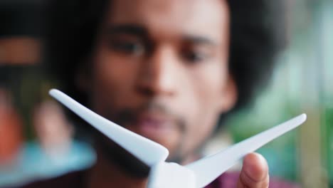 close up of african man holding model of wind turbine