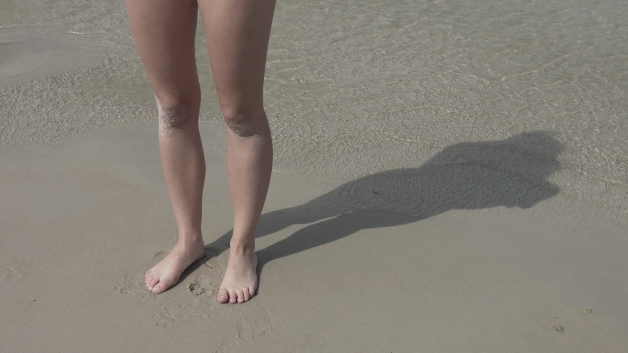 Gambe di donna sulla spiaggia