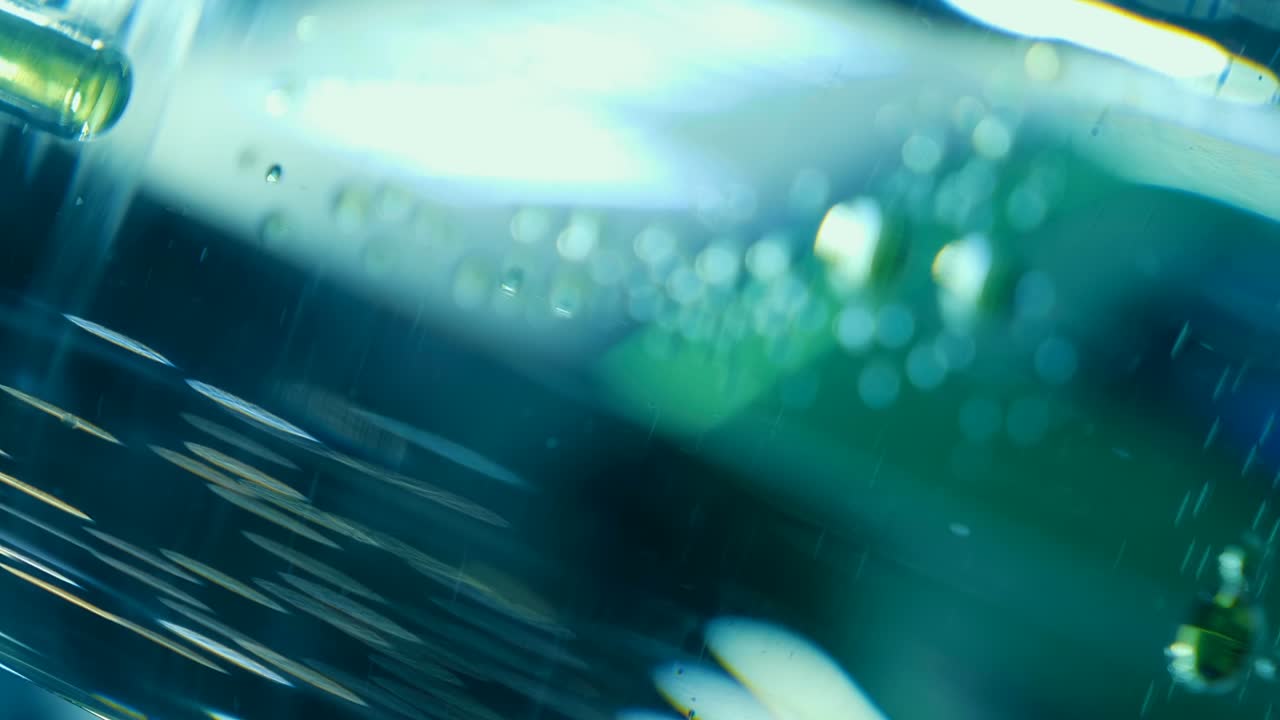 gotas de aceite verde caen lentamente al fondo en el agua