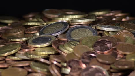 montaña de diferentes monedas de euro utilizadas girando con fondo negro