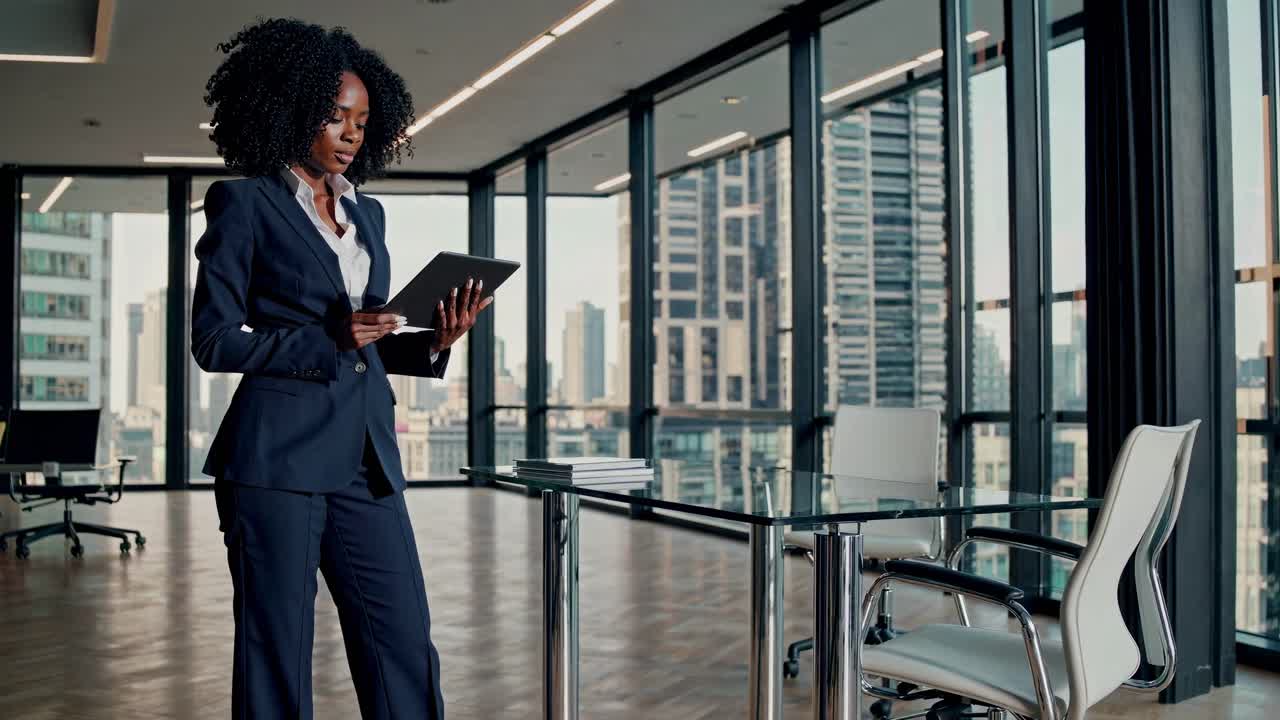En professionel kvinde læser en tablet på et moderne kontor