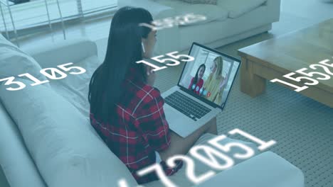 Animation-of-numbers-changing-over-woman-using-laptop-on-video-call-in-background