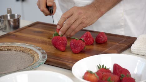 cortar fresas añadiendo en un cuenco para hacer casero sin lácteos vegano a base de plantas pastel de queso dieta saludable