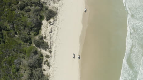 Toma-De-Vista-Superior-De-Dron-De-4k-De-Un-Auto-Conduciendo-A-Lo-Largo-De-La-Hermosa-Playa-En-La-Isla-De-Fraser,-Australia