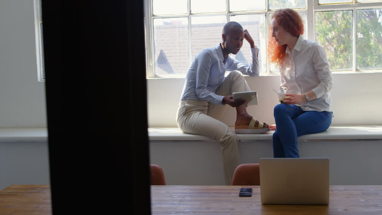 Side view of happy young mixed-race business team working on digital tablet in a modern office 4k
