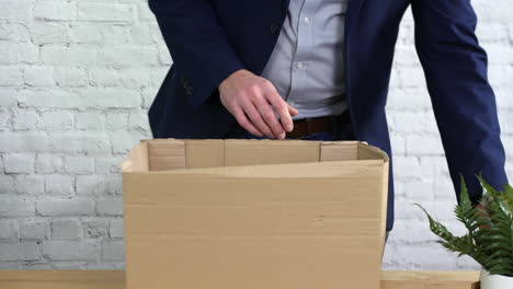 a man packing a box on his desk after being fired from work and is leaving his job as unemployed