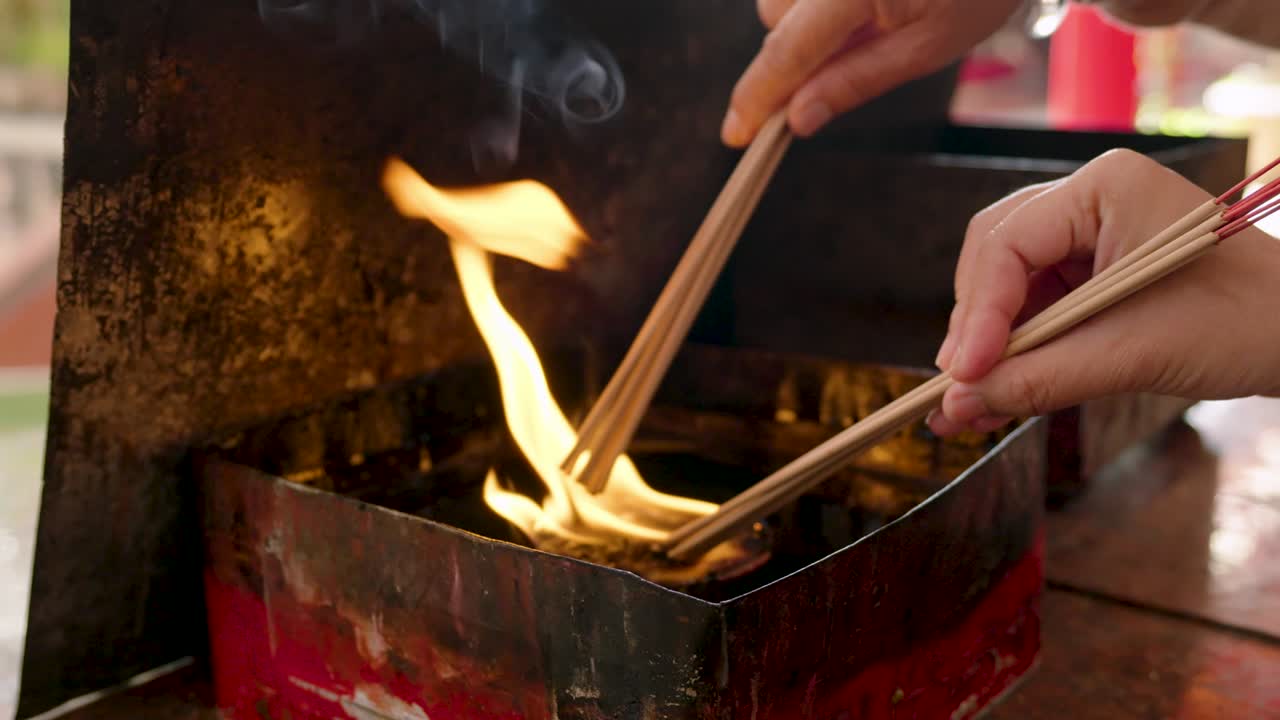 4k, Lighting a fire in an oil furnace to wait for tourists to bring incense and candles to burn at a Chinese shrine to pray to the gods