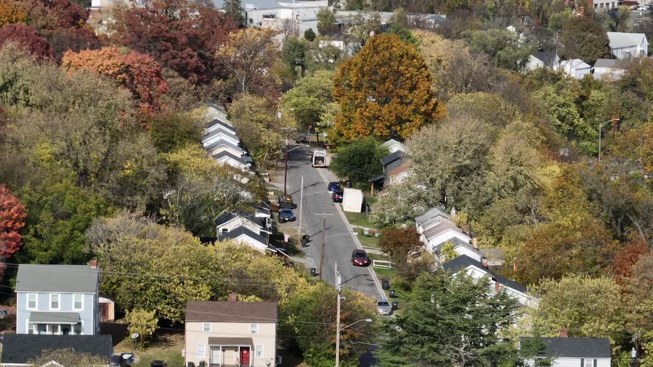 Tranquilla strada residenziale americana in autunno, con alberi colorati che circondano case a schiera e un quartiere pacifico. Atmosfera suburbana calma negli Stati Uniti. Ampia ripresa aerea