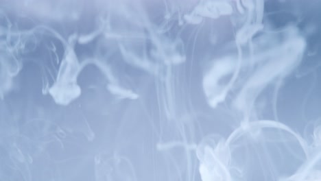 desenfoque de la leche que gotea en el agua a cámara lenta y el fondo del espacio de copia de color azul