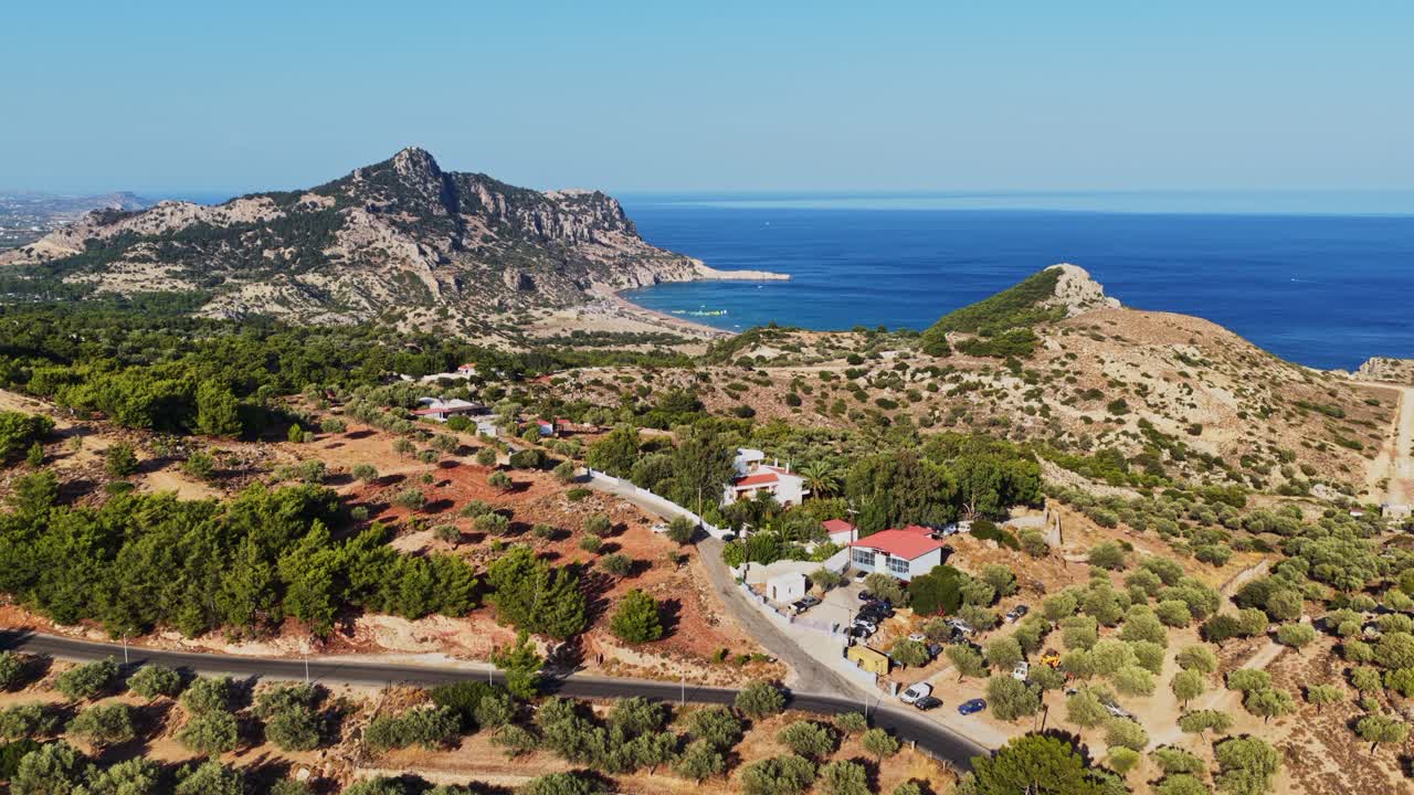 Aerial view of a scenic landscape with mountains, sea, roads and houses