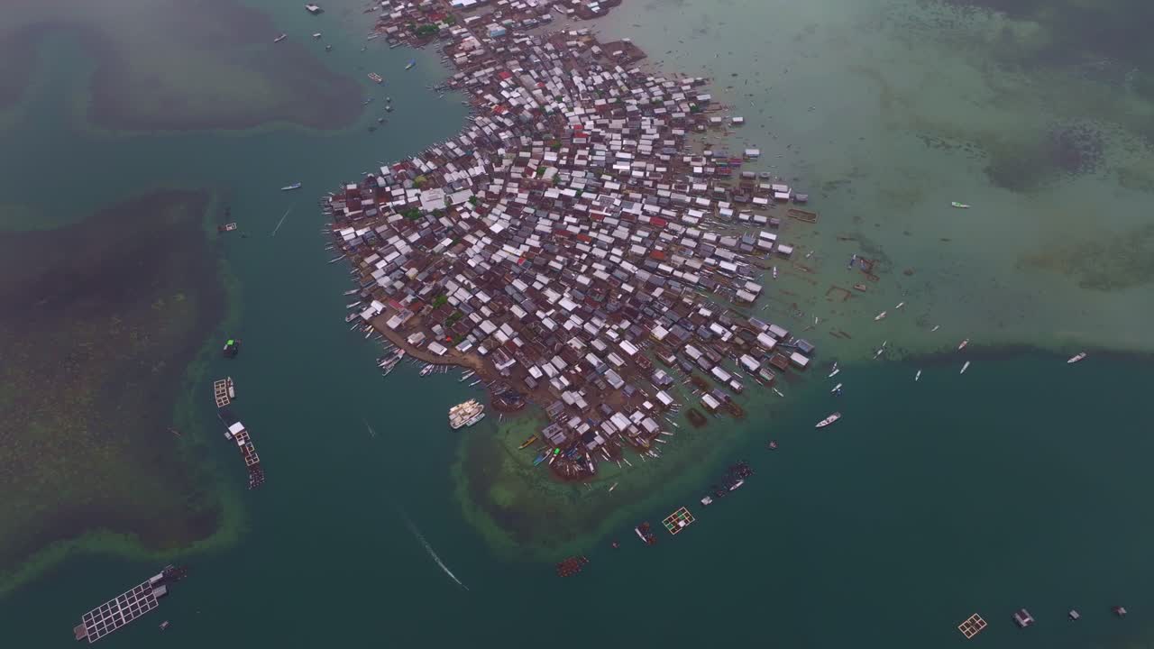 Barcos e casas agrupam-se ao longo da costa, Ilha Bungin, Indonésia