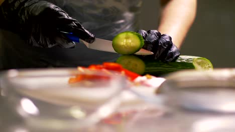 chef hands cutting fresh cucumber on round pieces for cooking vegetable salad