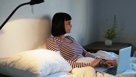 mujer usando computadora portátil en dormitorio 4k