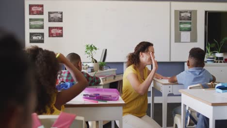 Video-Einer-Glücklichen-Kaukasischen-Lehrerin,-Die-Während-Des-Unterrichts-Mit-Einem-Afroamerikanischen-Jungen-In-Die-Hände-Klatscht