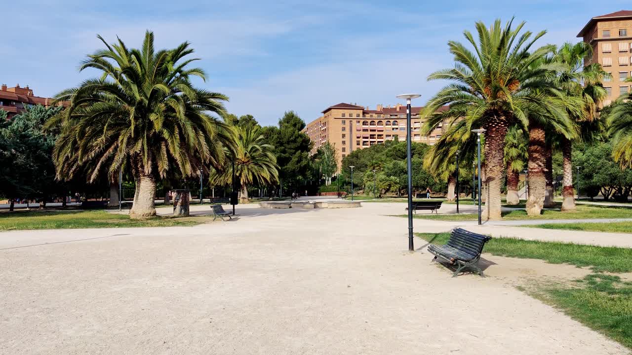 Slow motion of city park with palm trees on a sunny day in Zaragoza, Spain