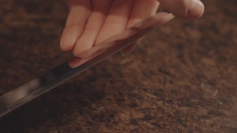 man checking the sharpness of a stainless knife in the kitchen