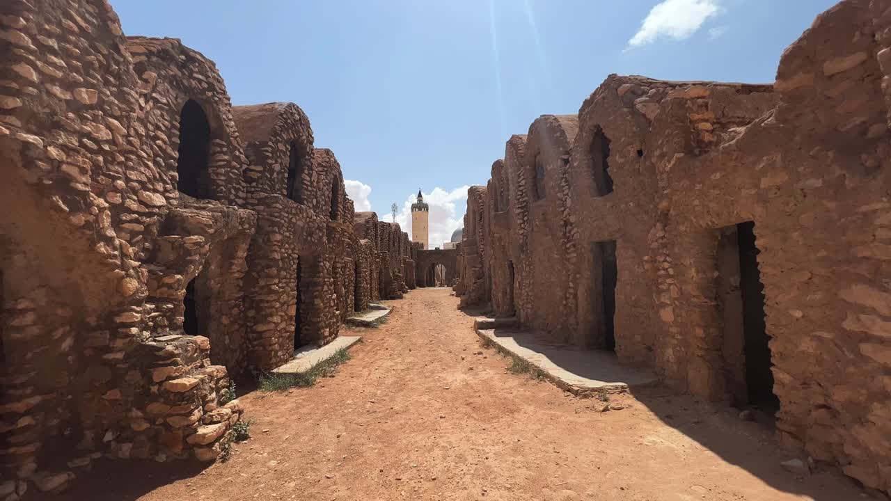 vista estática de la aldea de ksar hadada en túnez con una mezquita en el fondo