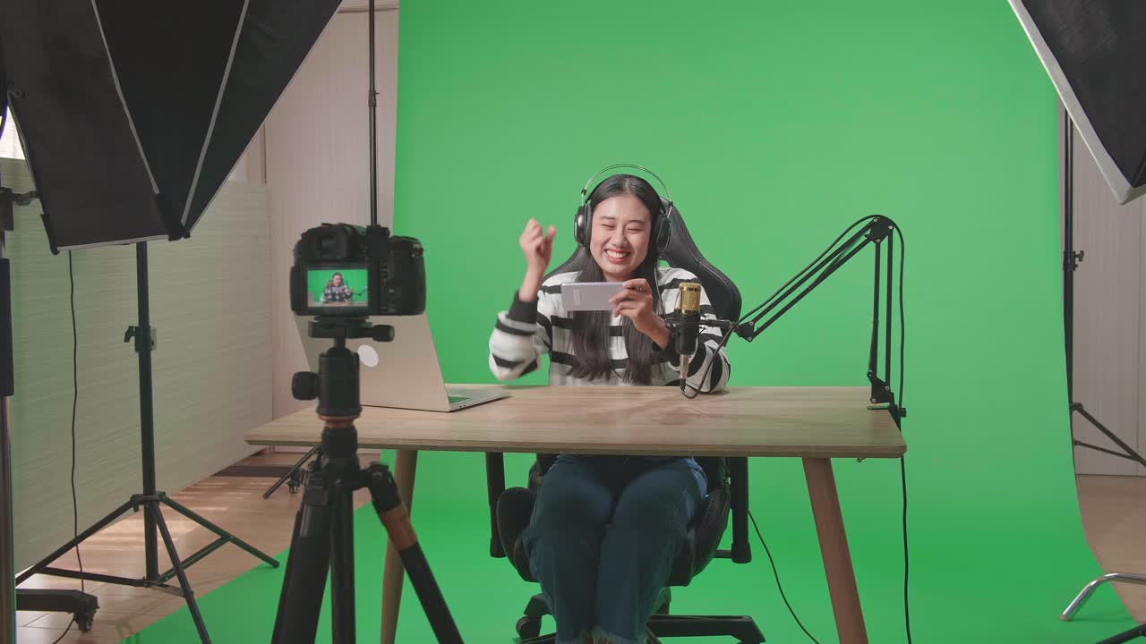 Woman Streaming a Mobile Game in a Green Screen Studio