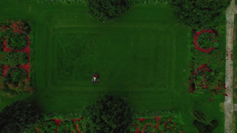 top-down-aerial-lawn-mowing-worker-in-Chicago-Grant-Park-then-tilting-up-and-revealing-chicago-skyspcrappers