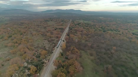 aerial tracking shot of a very historical sightseeing train travelling through the spanish countryside