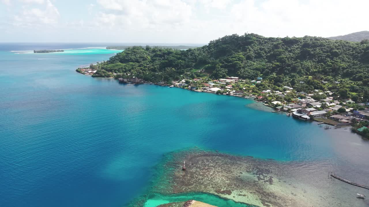 Aerial view of a tropical island with turquoise water and lush vegetation