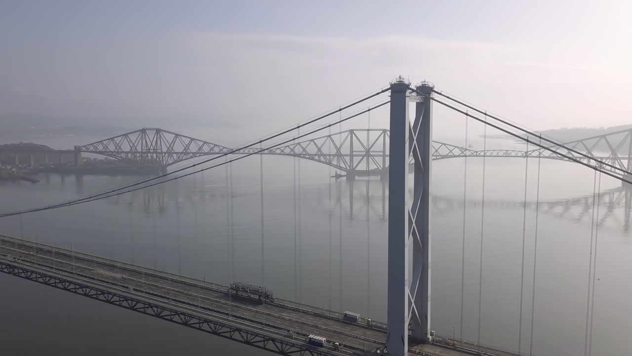 imágenes aéreas del antiguo puente de la carretera con el puente del ferrocarril al fondo en un día soleado en south queensferry en west lothian, escocia