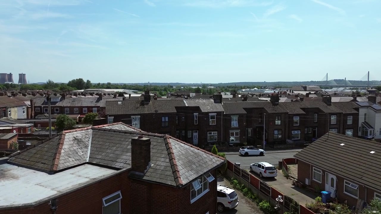 Vista aérea de telhados e jardins de casas geminadas de classe operária no Norte da Inglaterra, em estado de degradação.